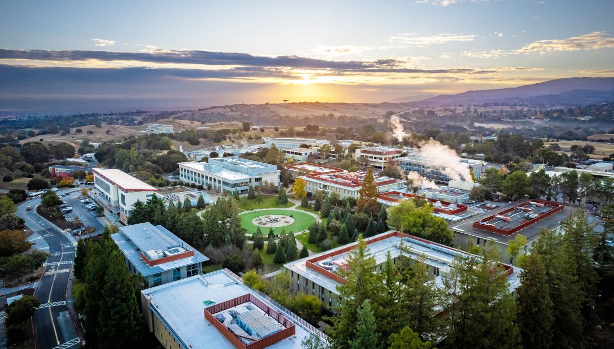 Ariel view showing the buildings and green spaces of SLAC's campus at sunset